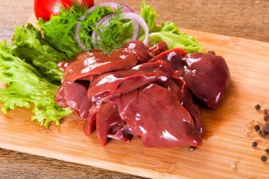 Raw chicken liver for cooking over wooden background clipart