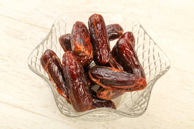 Tatlı meyve yığın kabın içinde ahşap arka plan üzerinde tarihleri.