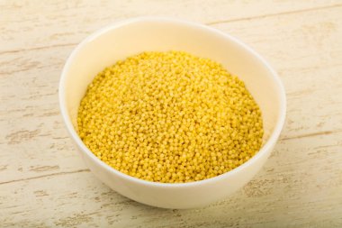 Kase ahşap arka plan üzerinde ham kuskus yığın