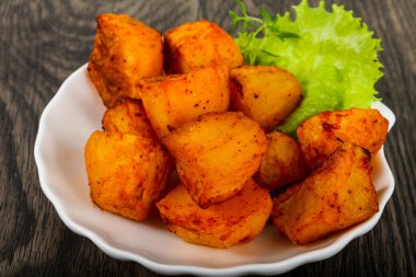 Ahşap arka plan üzerinde otlar fırında patates