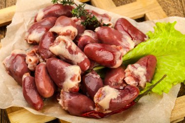 Çiğ tavuk kalbi kekik dalıyla istiflenmiş.