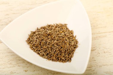 Kimyon tohumları yığın kase ahşap arka plan üzerinde