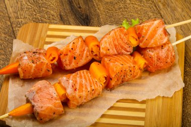 Pişmeye hazır baharatlı çiğ somon şişi.