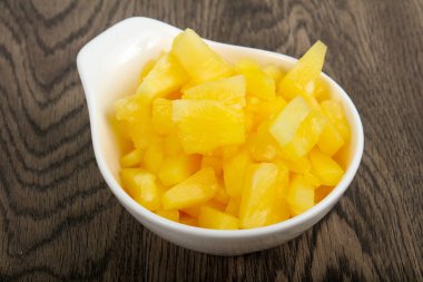 Ahşap arka plan üzerinde kase Konserve ananas