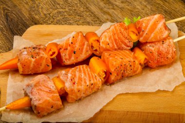 Pişmeye hazır baharatlı çiğ somon şişi.