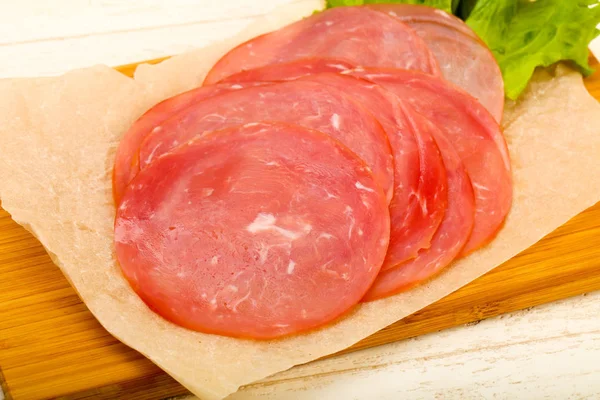 Wurst Scheiben Geschnitten Mit Salatblättern Über Holzuntergrund — Stockfoto