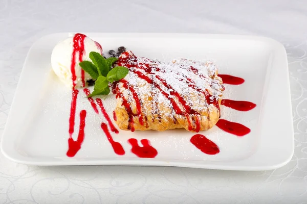 Strudel beyaz arka plan üzerinde beyaz tabak içinde dondurma ile