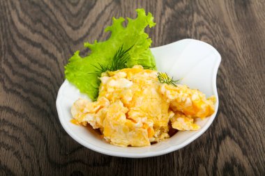 Ahşap arka plan üzerinde beyaz tabak içinde pişmiş yumurta