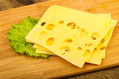 Ahşap arka plan üzerinde dilimlenmiş peynir salata yaprakları