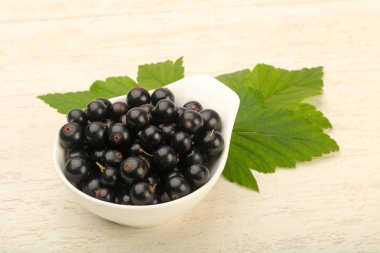 Olgun siyah kuş üzümü ile yaprak kase