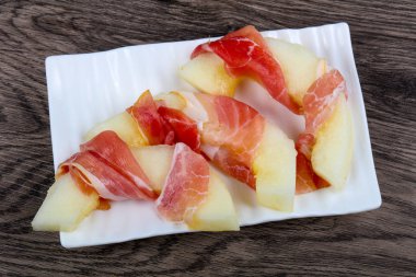 Ahşap arka plan üzerinde prosciutto ile kavun