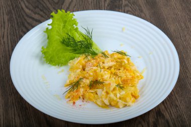 Ahşap arka plan üzerinde beyaz tabak içinde pişmiş yumurta