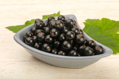 Olgun siyah kuş üzümü ile yaprak kase