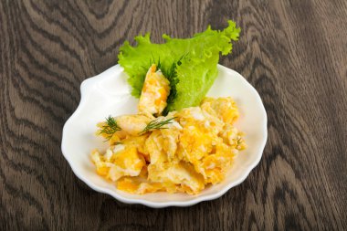 Ahşap arka plan üzerinde beyaz tabak içinde pişmiş yumurta