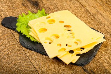 Ahşap arka plan üzerinde dilimlenmiş peynir salata yaprakları