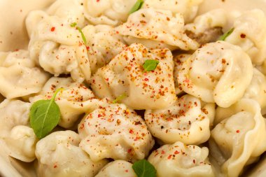 Otlar, yağlar ve baharatlar ile haşlanmış mantı