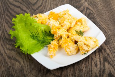 Ahşap arka plan üzerinde beyaz tabakta Yumurta