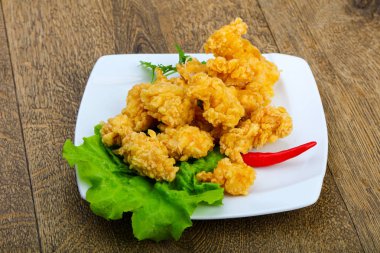 Çıtır tavuk nuggets ahşap arka plan üzerinde baharatlar ile