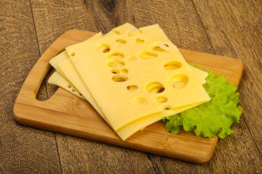 Ahşap arka plan üzerinde dilimlenmiş peynir salata yaprakları