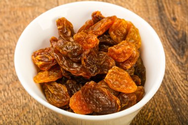 Ahşap arka plan üzerinde kase kuru kuru üzüm