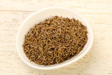 Kimyon tohumları yığın içinde kase ahşap arka plan üzerinde