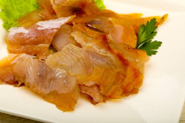 Yayın balığı fileto carpaccio beyaz plaka üzerinde füme