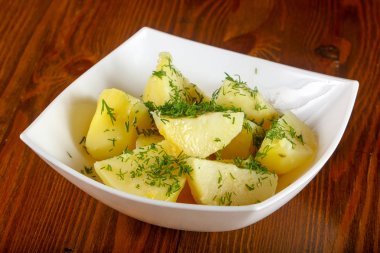 Ahşap arka plan üzerine dereotu ile haşlanmış patates