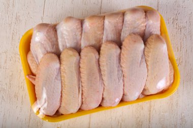 Ahşap arka plan üzerinde yemek pişirmek için çiğ tavuk kanadı