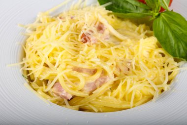 Makarna Carbonara fesleğen yaprakları hizmet.