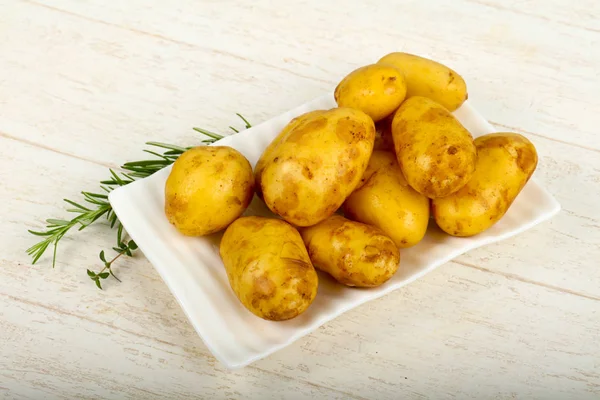 Ahşap arka plan üzerinde otlar ile ham genç patates