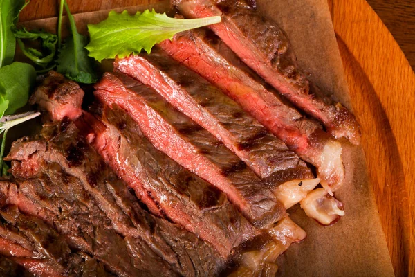 木製の背景以上の血と牛ステーキ — ストック写真