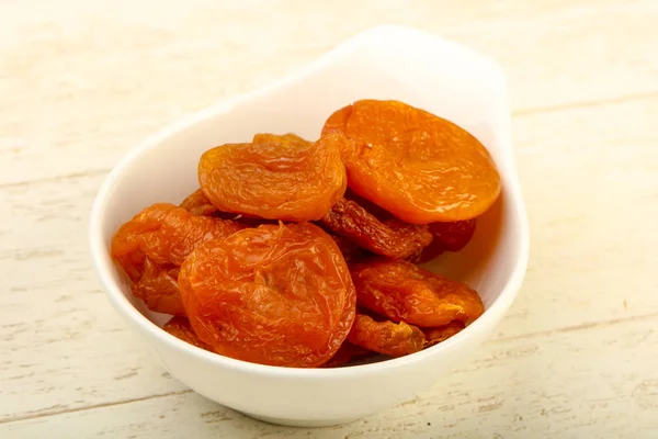 stock image Dried apricots heap in the bowl over wooden background