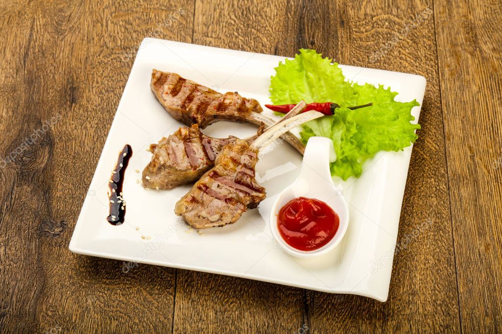 Grilled lamb with tomato sauce served salad leaves