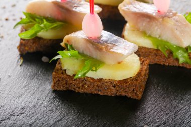 Kanepe ringa balığı ve ahşap arka plan üzerinde patates ile