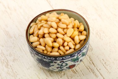 Sedir fındık yığın içinde kase ahşap arka plan üzerinde