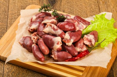 Çiğ tavuk kalbi kekik dalıyla istiflenmiş.