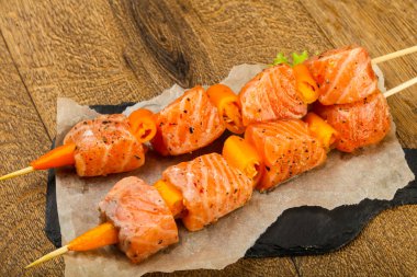 Pişmeye hazır baharatlı çiğ somon şişi.