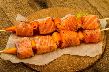 Pişmeye hazır baharatlı çiğ somon şişi.