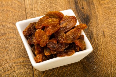 Ahşap arka plan üzerinde kase kuru kuru üzüm