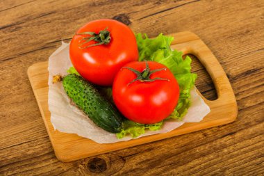 Salatalık ve domates salatası ile ahşap arka plan üzerinde bırakır