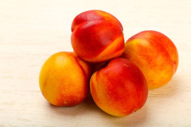 Olgun nektarin yığın ahşap arka plan üzerinde