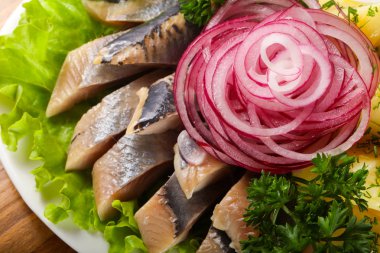 Kırmızı soğan ringa balığı filetosu patates ile hizmet