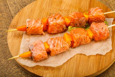 Pişmeye hazır baharatlı çiğ somon şişi.