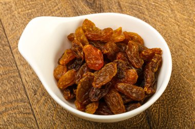 Ahşap arka plan üzerinde kase kuru kuru üzüm