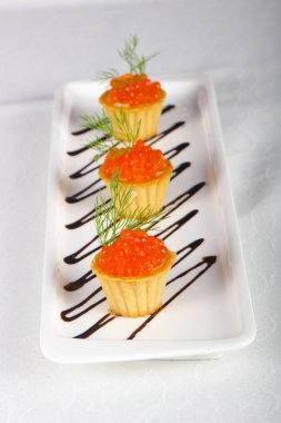 Beyaz masada kırmızı havyar tartlets