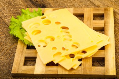 Ahşap arka plan üzerinde dilimlenmiş peynir salata yaprakları