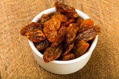 Ahşap arka plan üzerinde kase kuru kuru üzüm