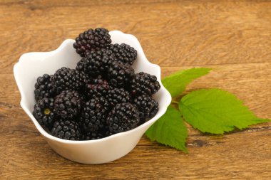 Böğürtlen yaprakları üzerinde ahşap arka plan ile