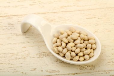 Kase ahşap arka plan üzerinde beyaz kuru fasulye