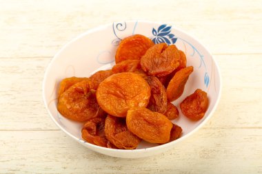 Kuru Kayısı yığın içinde kase ahşap arka plan üzerinde